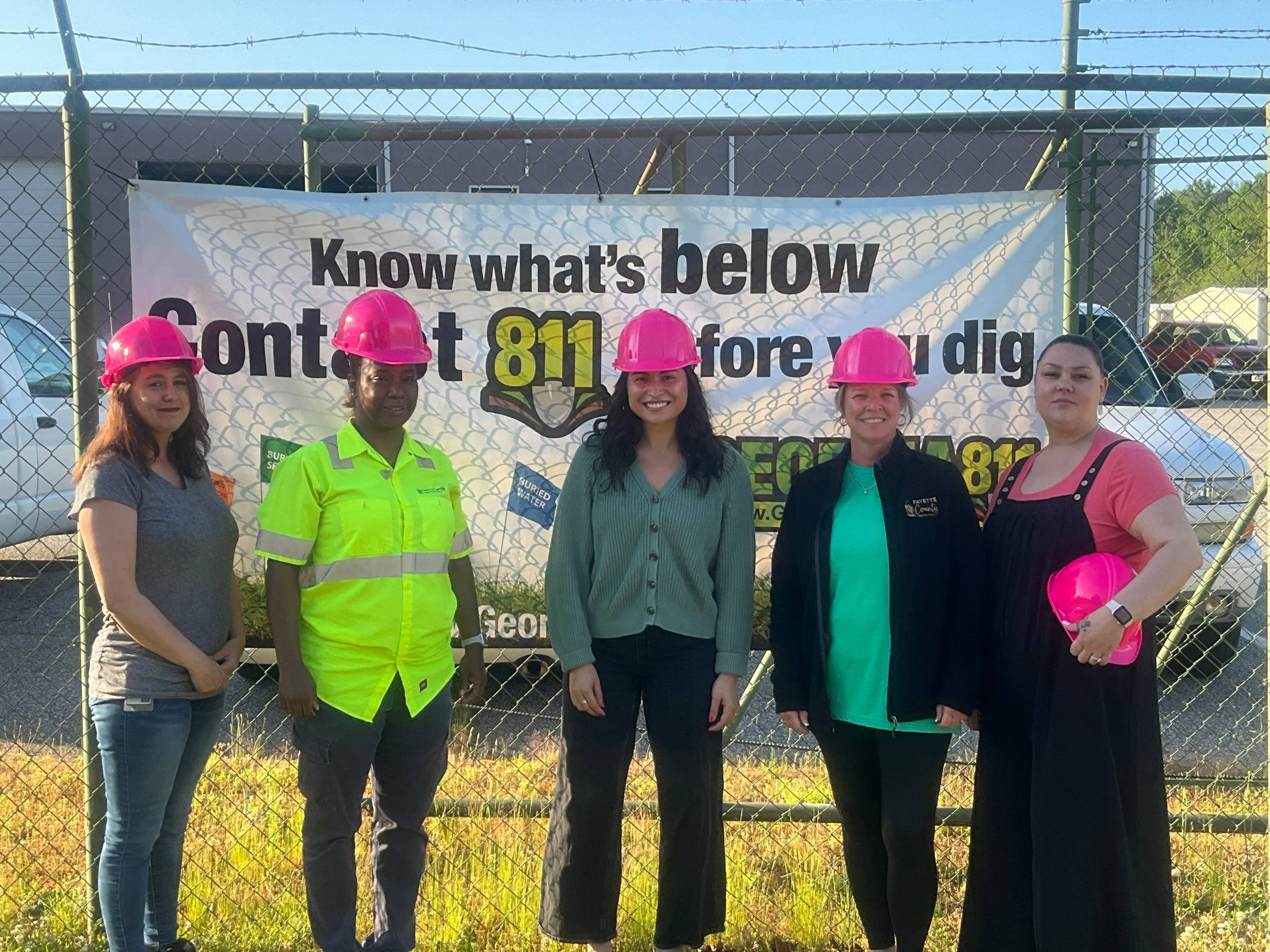 Women of the Public Works department pose in front of 811 sign
